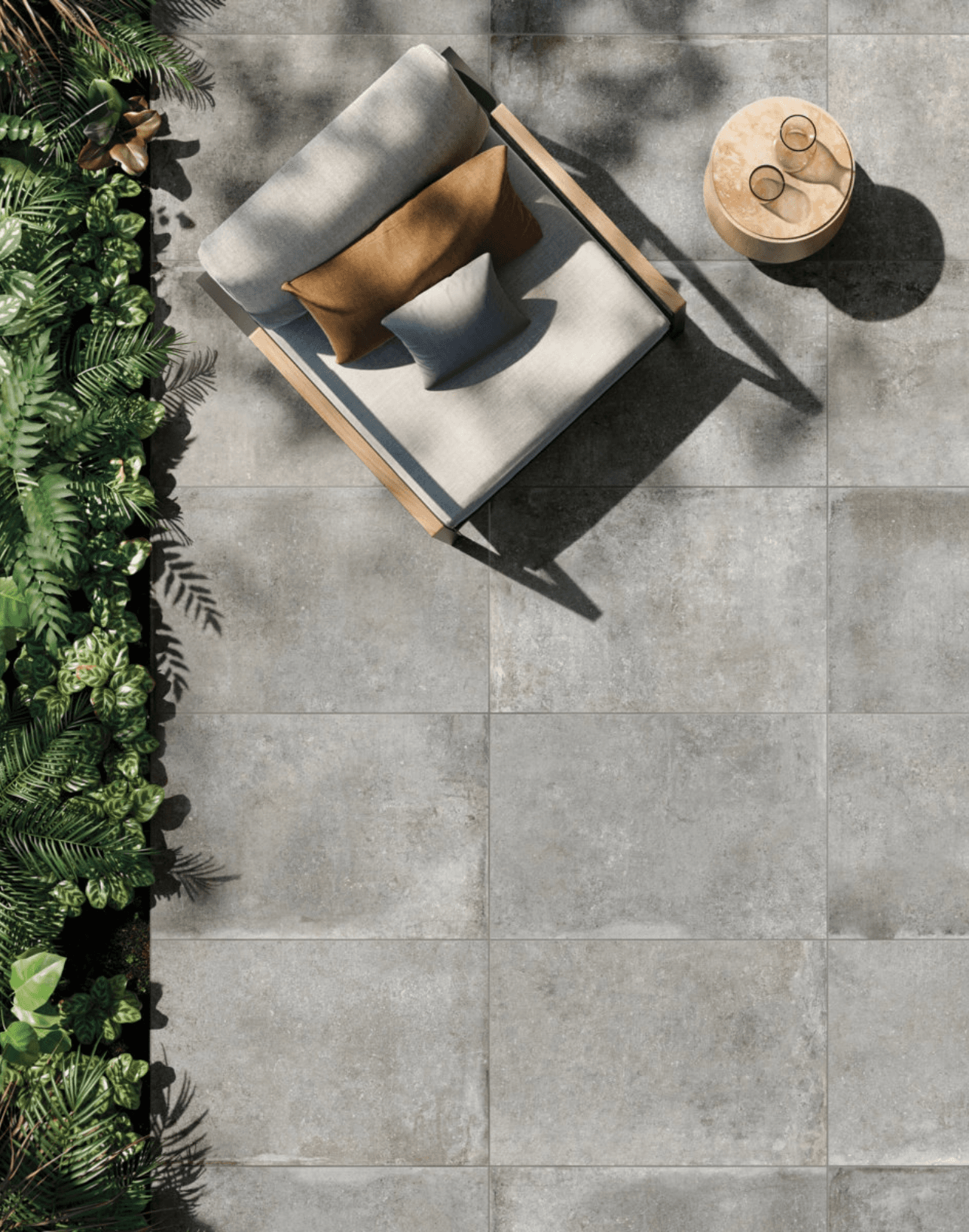 Grijze keramische terrastegels met loungebed door Keistad Tegelwerken