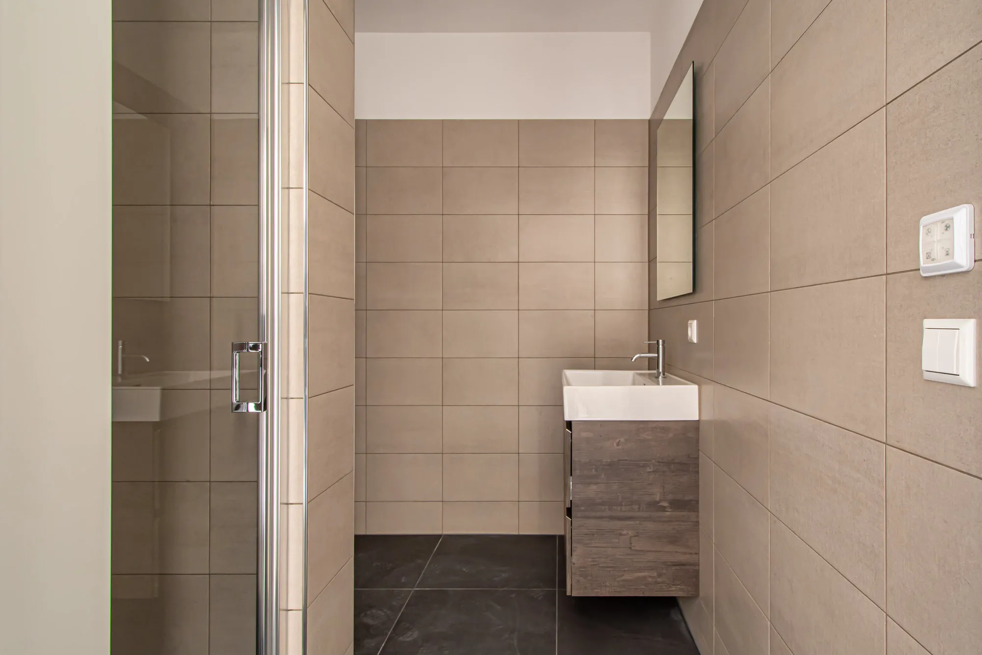 Badkamer met beige wand- en vloertegels - tegelzetter in Ermelo